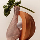 Raw turkey leg, sliced pumpkin, egg, spinach, and blueberry arranged together, showcasing the whole food ingredients in Purely Golden Foods turkey dog food formula