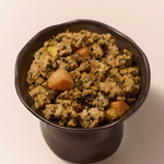 Purely Golden Foods turkey dog food served in a dark ceramic bowl, showing visible whole food ingredients including pumpkin, spinach and egg.